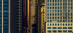 Close up of buildings on Wall Street in NYC with a mix of light & shadows during a sunset (source: Getty Images/500px Prime)