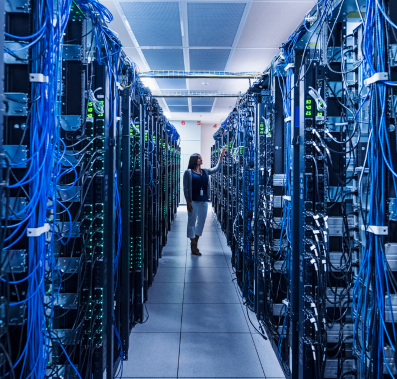 Woman standing in aisle of well lit server room (credit: Getty Images)